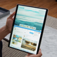 A person holding up a Microsoft Windows device with Windows 11 in verticle tablet mode.